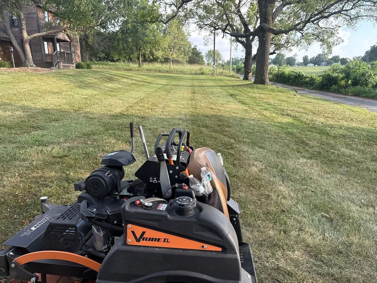 Zero-turn mower on a large open lawn
