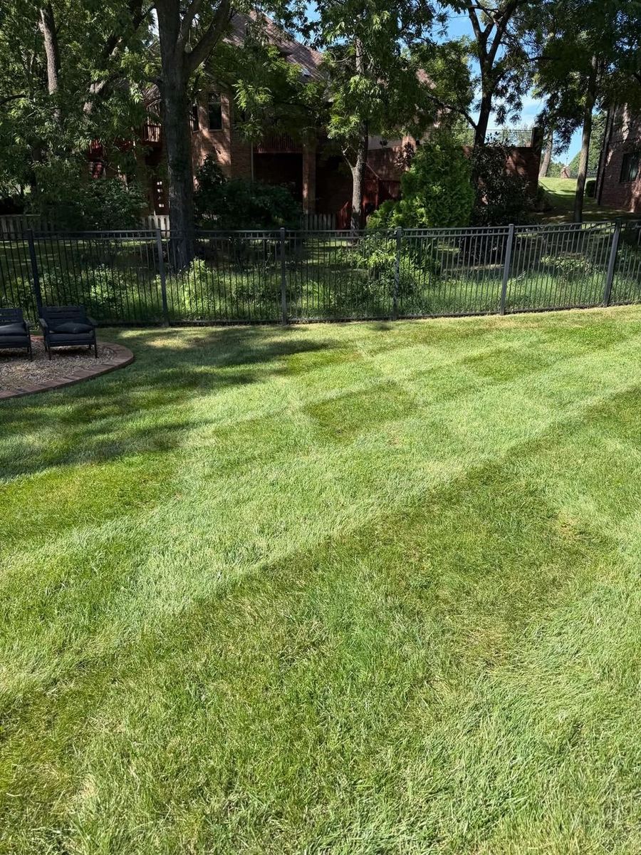 Striped backyard lawn beside a patio seating area